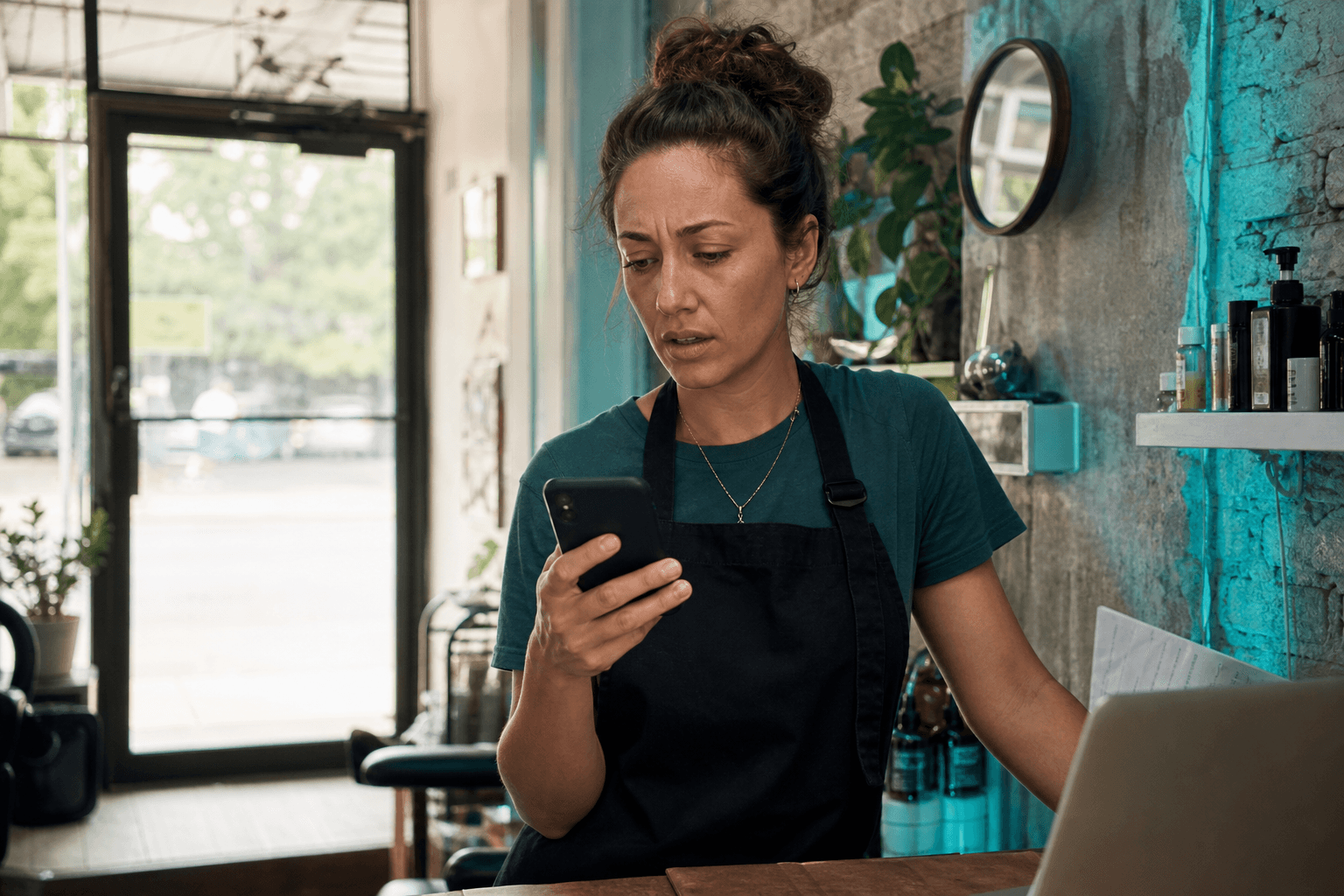 Business owner checking missed call notifications at a busy front desk